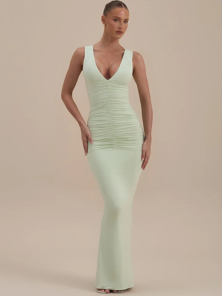 Woman wearing a light green evening gown against a beige background