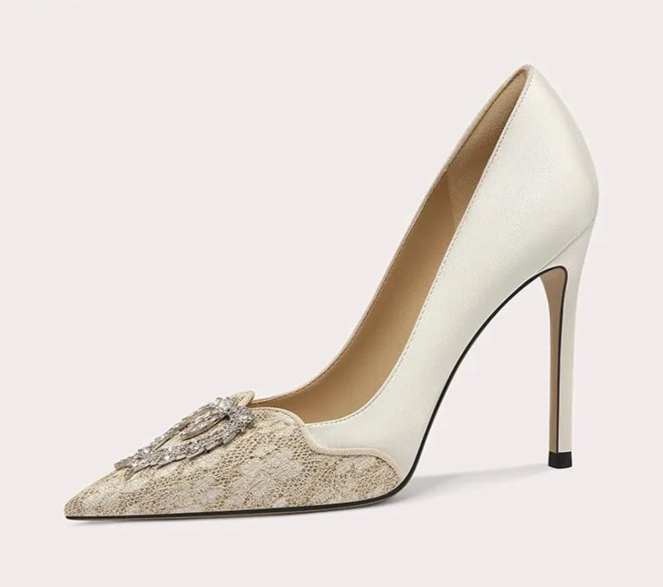 White high-heeled shoe with decorative element on a light gray background