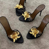 Black stiletto heels with gold floral embellishment