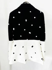 Black and white polka dot blouse on a mannequin against a white background