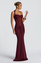 Woman wearing a burgundy evening gown on a white background