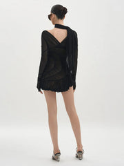 Woman wearing a black dress with a sheer overlay on a white background