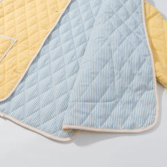Quilted baby blanket with blue and white striped pattern and yellow borders on a light gray background