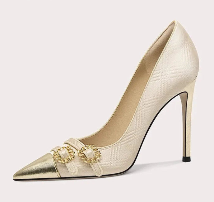 Beige high-heeled shoe with gold chain detail on a white background