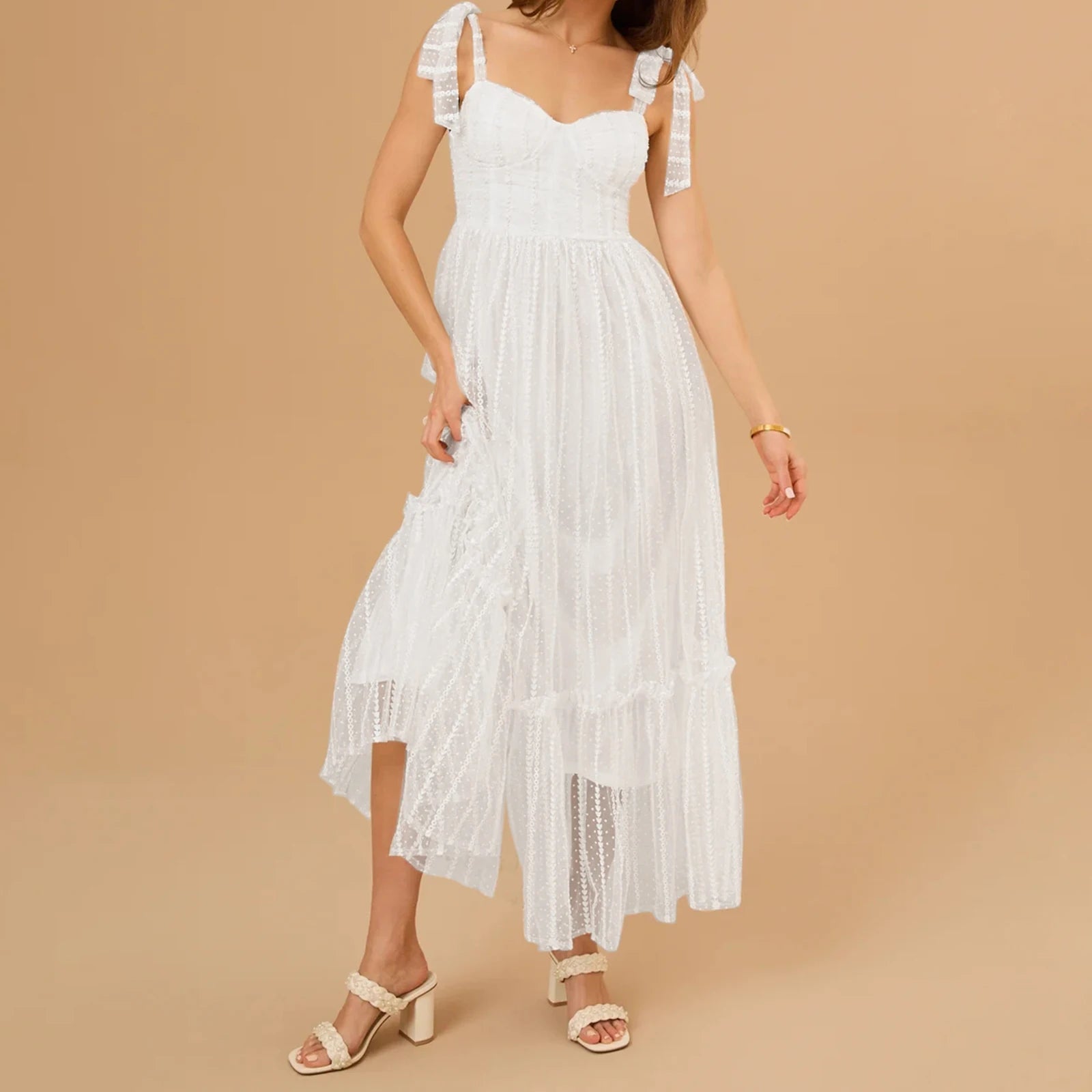 Woman wearing a white lace dress against a beige background