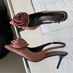 Brown high-heeled shoes with floral embellishments on a chair.