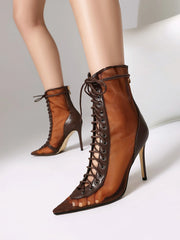 Brown lace-up high-heeled boots on a neutral background