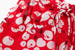 Close-up of the cherry-like print on a red ruffled midi dress