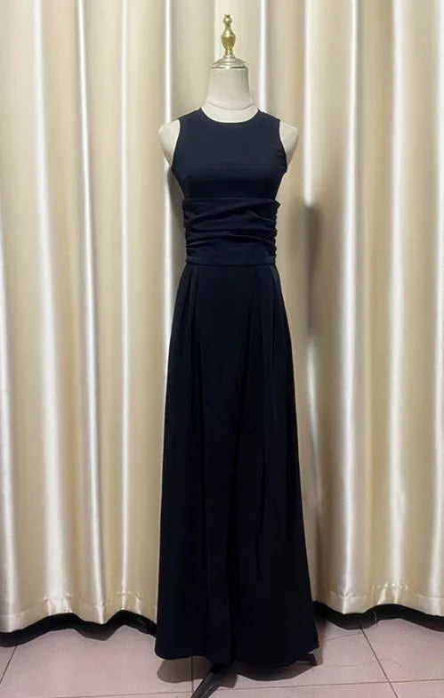 Navy blue evening pant suit on a mannequin against a white curtain background