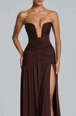 Brown strapless gown with a deep neckline and high slit on a gray background