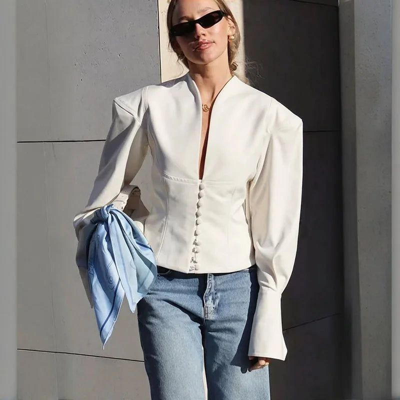 White v-neck slim-fit blazer with button front and full sleeves, styled with blue jeans