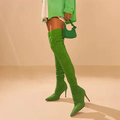 Green crystal embellished over the knee boots worn with a white skirt and green top.