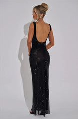 Woman wearing a black sequin gown against a white background