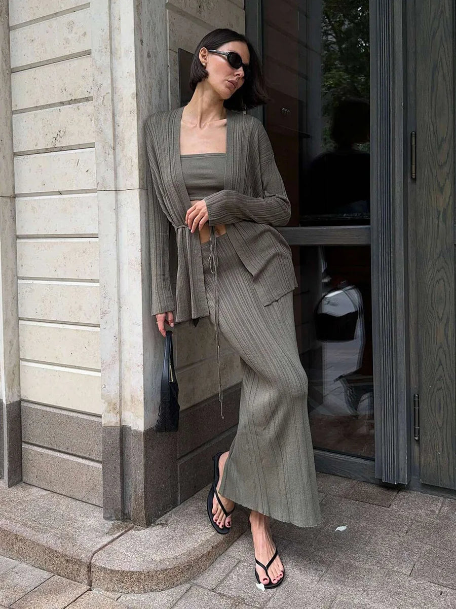 Woman in a gray outfit standing outside a building