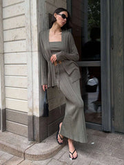 Woman in a gray outfit standing outside a building