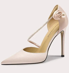 Beige high-heeled shoe with a decorative strap on a white background
