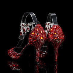 Red high-heeled shoes with crystal embellishments on a black background
