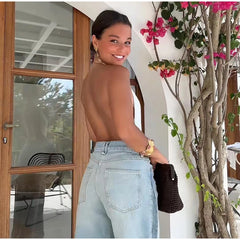 Woman standing in a doorway with a floral plant to her right