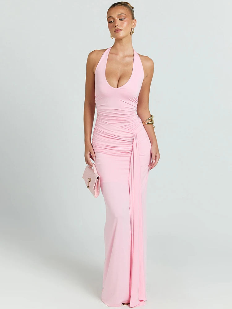 Woman wearing a pink halter neck gown on a light gray background