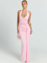 Woman wearing a pink halter neck gown on a light gray background