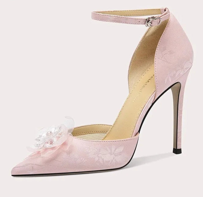 Pink high-heeled shoe with floral design on a white background