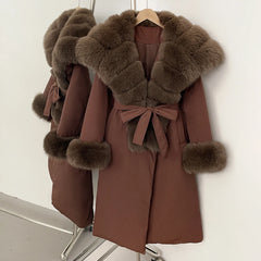 Brown coat with fur trim on a hanger against a white background
