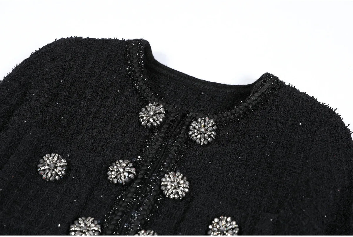 Black textured garment with decorative buttons on a white background