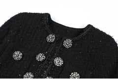 Black textured garment with decorative buttons on a white background