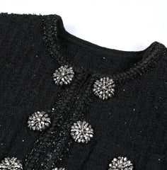 Black textured garment with decorative buttons on a white background