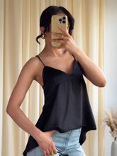 Person wearing a black top and light blue jeans, taking a mirror selfie.