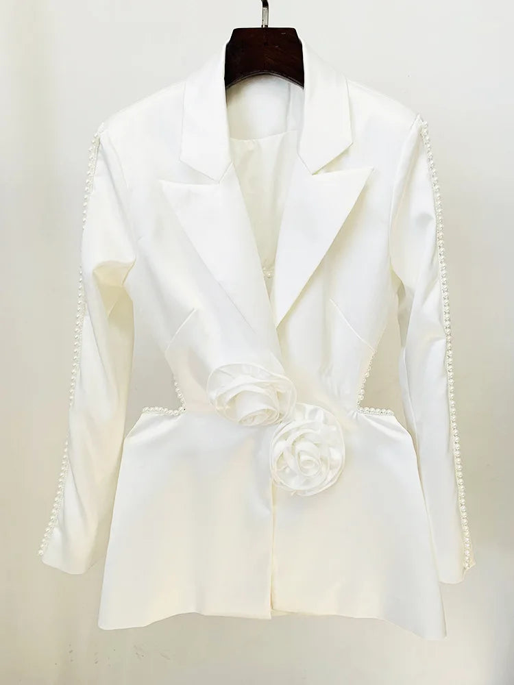 White blazer with floral details on a hanger against a white background