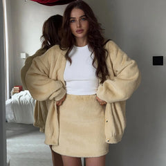 Woman wearing a beige fleece outfit in a room.