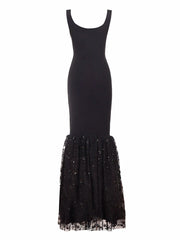 Black dress with a sheer, embellished bottom half on a white background