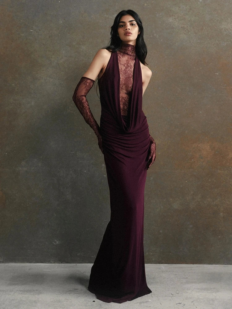 Woman wearing a dark purple evening gown against a gray background