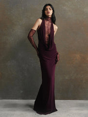 Woman wearing a dark purple evening gown against a gray background
