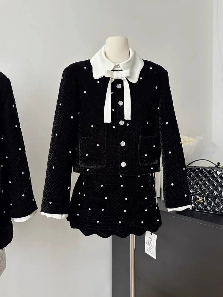 Black outfit with white details on a mannequin against a neutral background