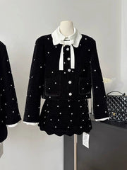 Black outfit with white details on a mannequin against a neutral background