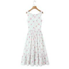 White dress with pink floral pattern on a wooden hanger against a white background