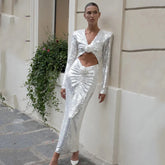 Sequin V-neck cutout midi dress worn by a model leaning against a wall.