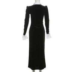 Black velvet dress with white cuffs on a mannequin against a white background