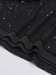 Close-up of black fabric with white speckles on a light gray background