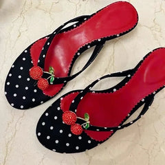 Top down view of polka dot kitten heel flip flops with cherry embellishment