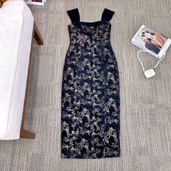 Floral patterned dress on a gray carpet with a magazine and necklace nearby.