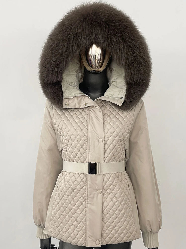 Beige quilted jacket with a large fur hood on a mannequin against a white background