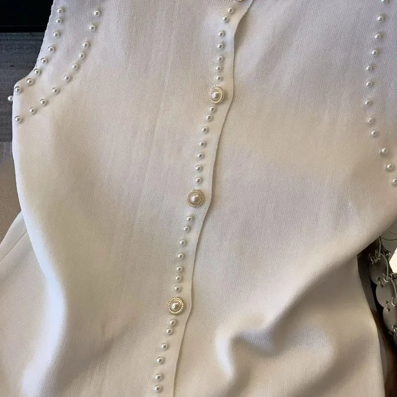 Close-up of a white blouse with pearl buttons on a mannequin.