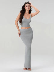 Woman wearing a gray knit top and skirt set on a white background