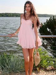 Woman in a pink dress standing by a body of water