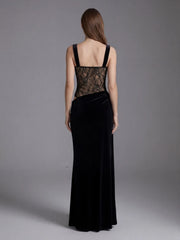Woman wearing a black evening gown with lace detailing on a gray background