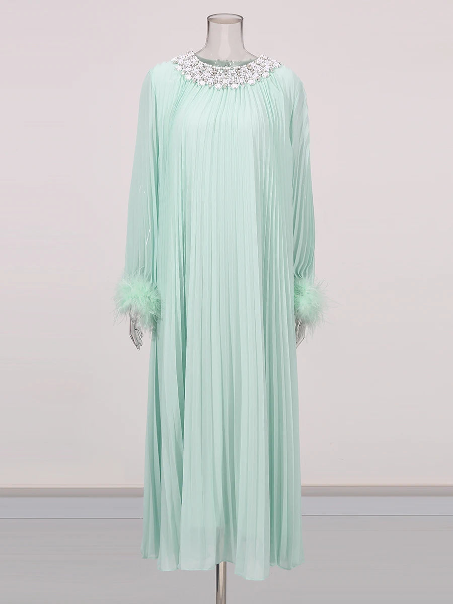 Mint green dress with floral embellishments on a mannequin against a light gray background