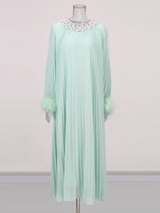 Mint green dress with floral embellishments on a mannequin against a light gray background